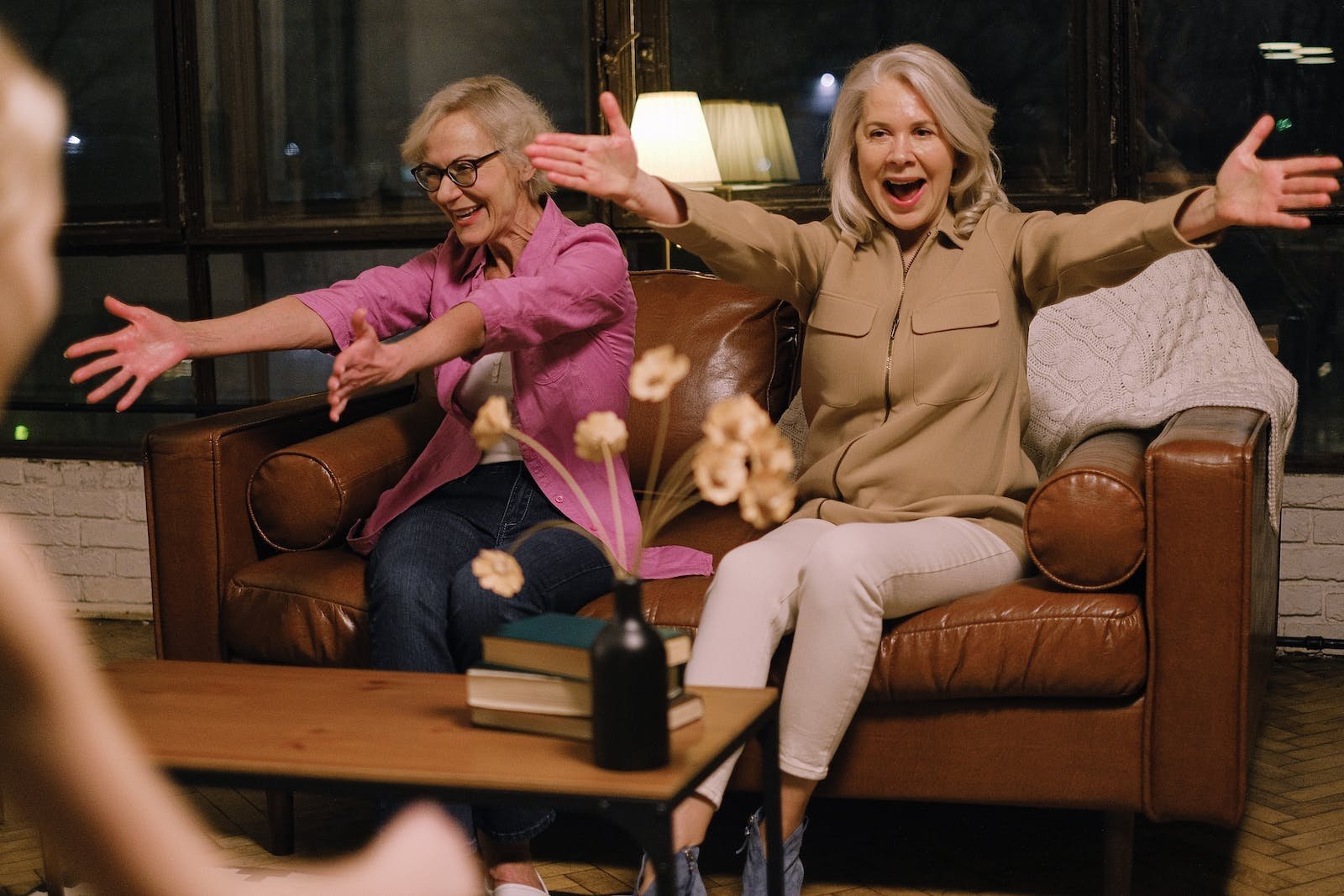 Woman in Brown Coat Sitting Beside Woman in Brown Sweater